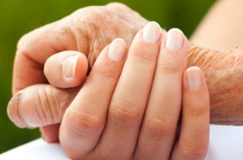 A Caregiver Holding the Old Woman’s Hand